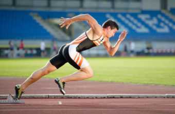 Sprinter leaving starting blocks on the running track. Explosive start.