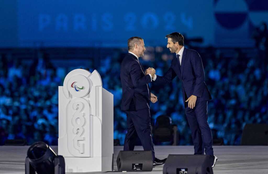 Paralympics Paris 2024 Eröffnungsfeier - Andrew Parsons, Präsident des Internationalen Paralympischen Komitees, schüttelt Tony Estanguet, Präsident von Paris 2024, auf der Bühne bei der Eröffnungsfeier der Paralympischen Spiele 2024 in Paris die Hand - Copyright Foto: OIS/IOC/Hassan Wamwayi Paralympics Paris 2024 Eröffnungsfeier - Andrew Parsons, Präsident des Internationalen Paralympischen Komitees, schüttelt Tony Estanguet, Präsident von Paris 2024, auf der Bühne bei der Eröffnungsfeier der Paralympischen Spiele 2024 in Paris die Hand - Copyright Foto: OIS/IOC/Hassan Wamwayi